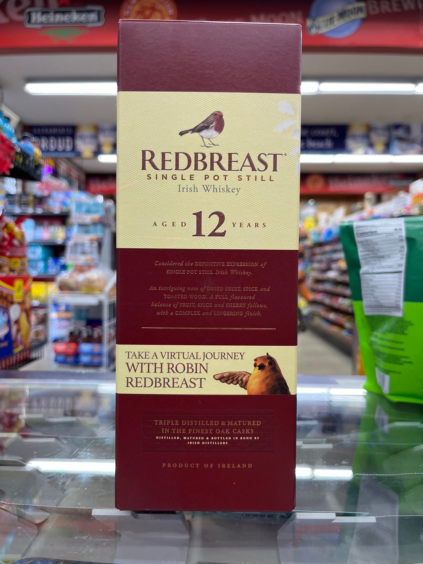 A bottle of Redbreast 12yrs old Irish Whiskey on display in a retail setting with a focus on the label and packaging.