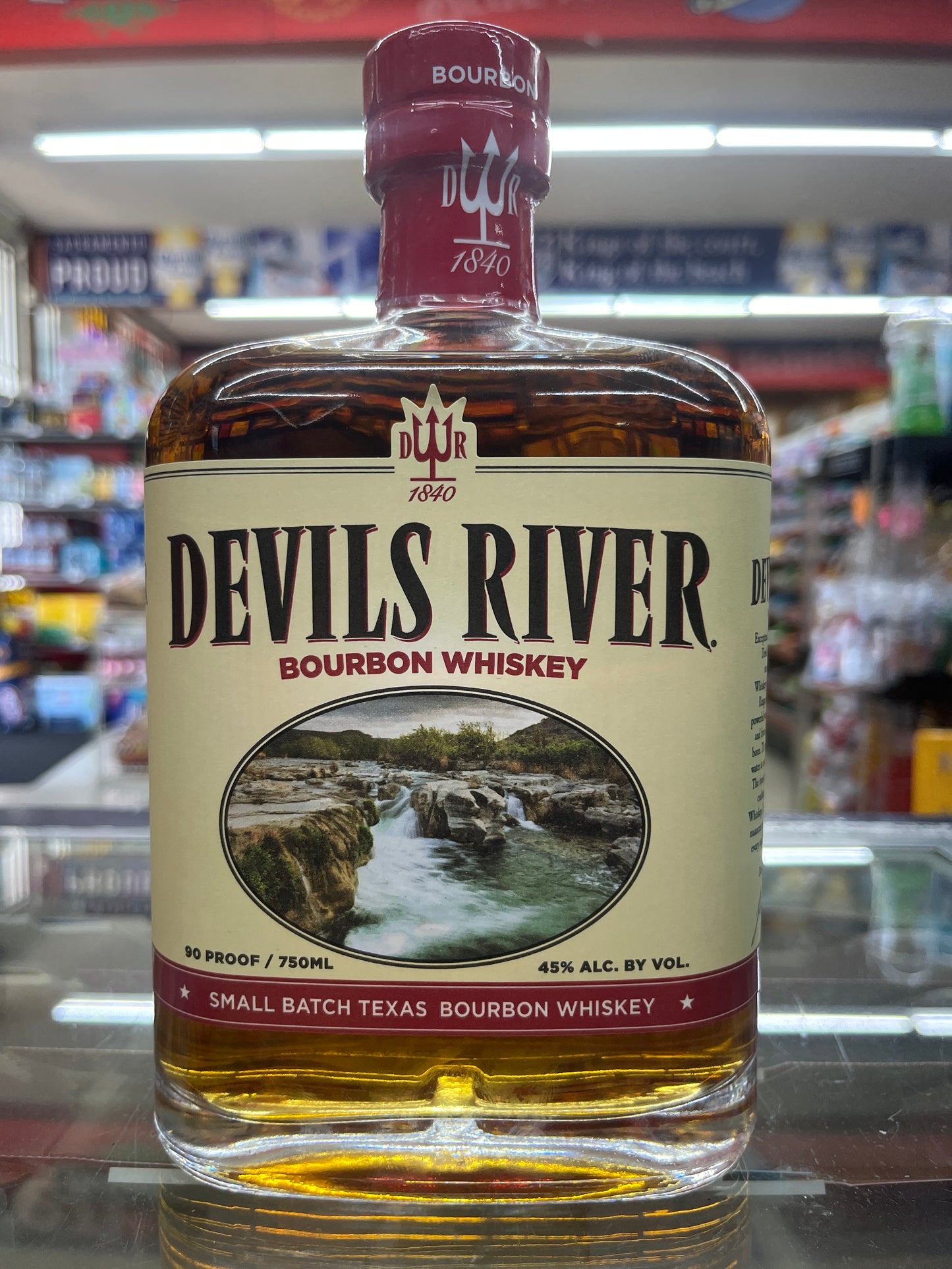 Devil's River Bourbon Whiskey bottle with a scenic label in a store setting