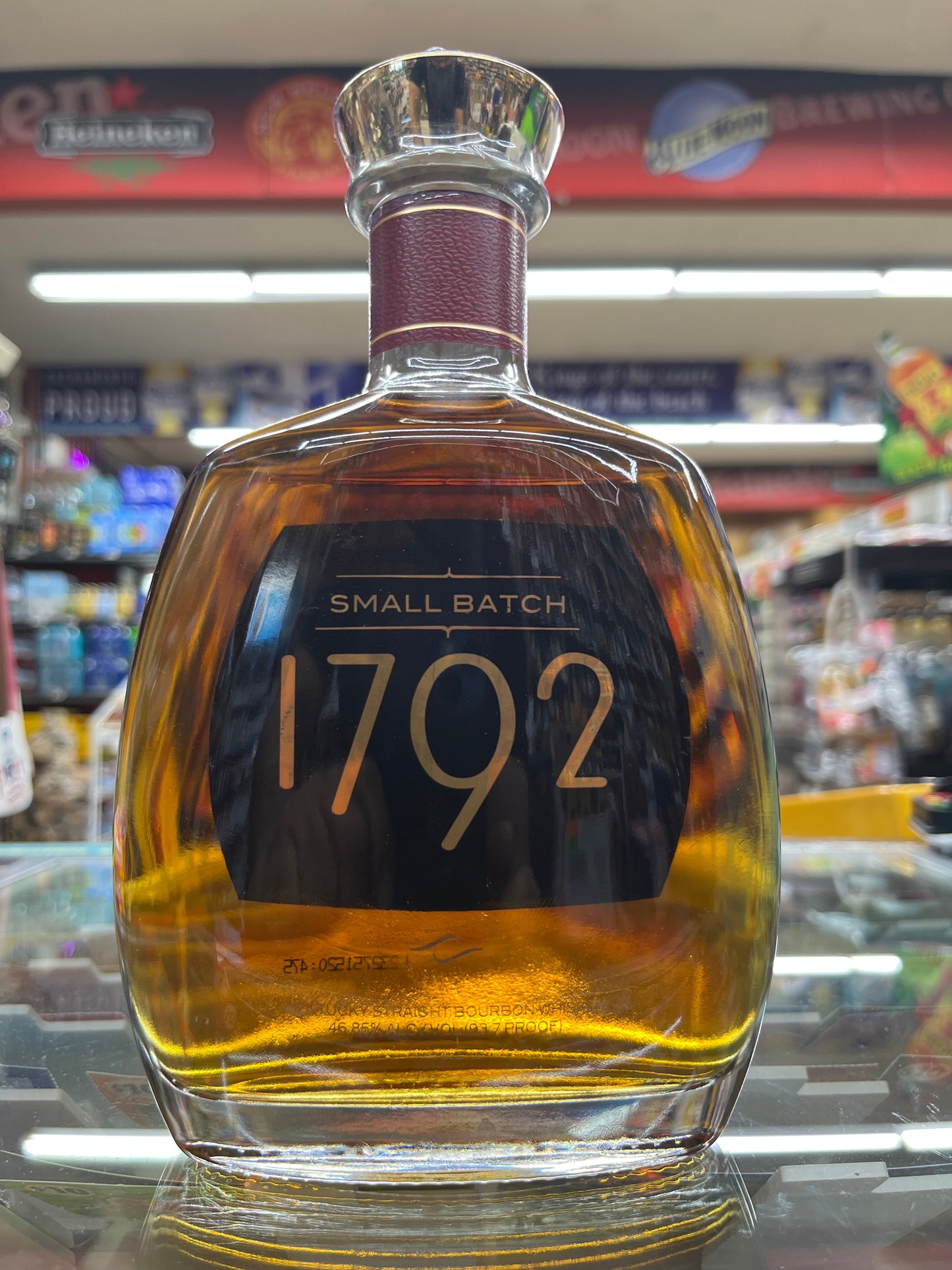 Bottle of 1792 Small Batch Bourbon whiskey with a blurred store shelf in the background.
