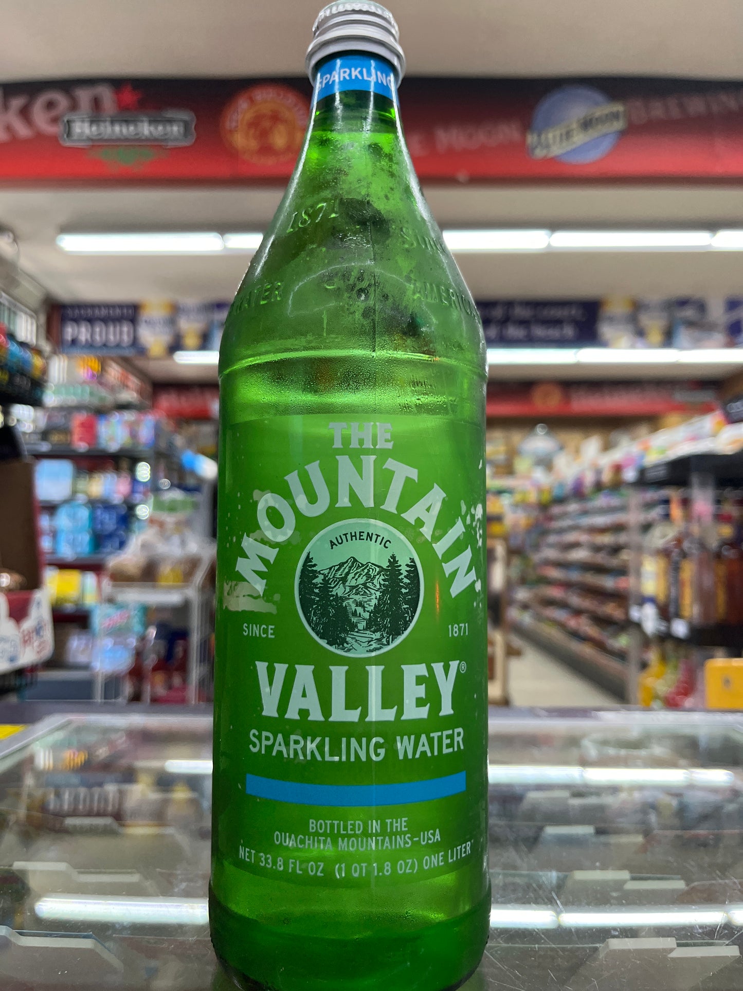 Green bottle of Mountain Valley sparkling water in a store setting