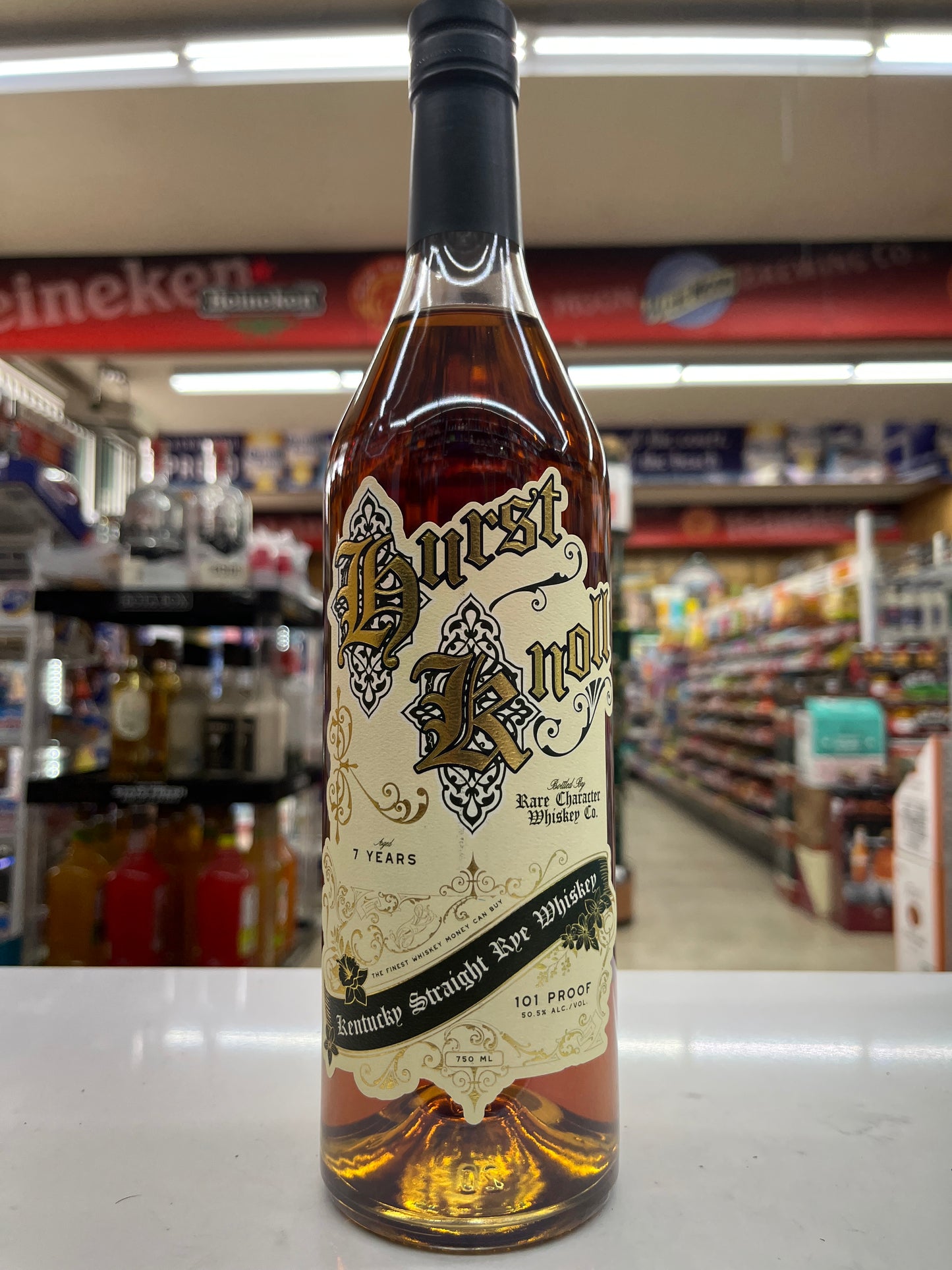 Bottle of Hurst Knoll Kentucky Straight Rye  Whiskey 7 years old by Rare Character whiskey Company sitting on a shelf with a store background.