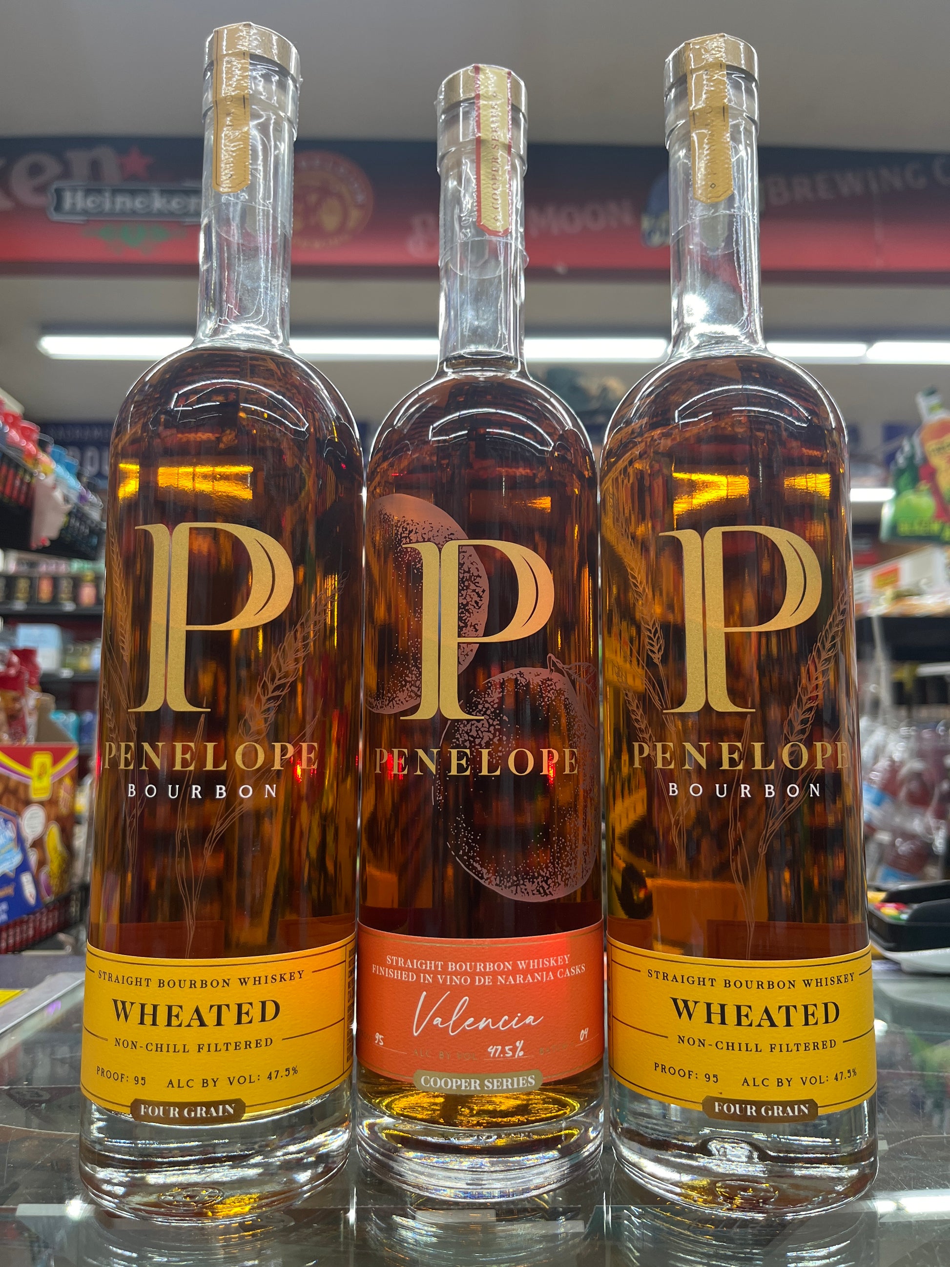 Three bottles of Penelopé Valencia Bourbon along with Penelope Wheated bourbon non a shelf with blurred background in a store in East Sacramento