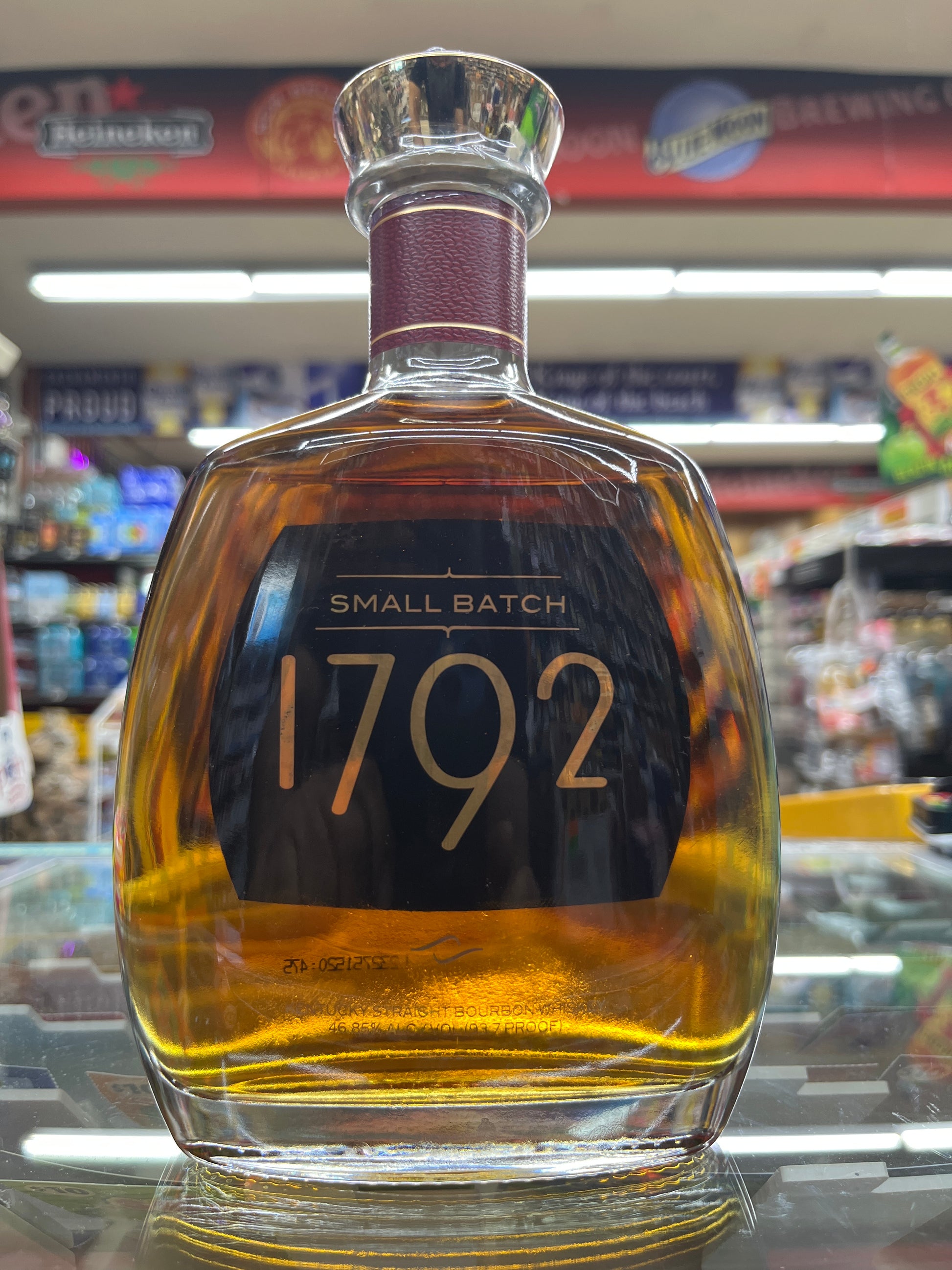 Bottle of 1792 Small Batch Bourbon whiskey with a blurred store shelf in the background.