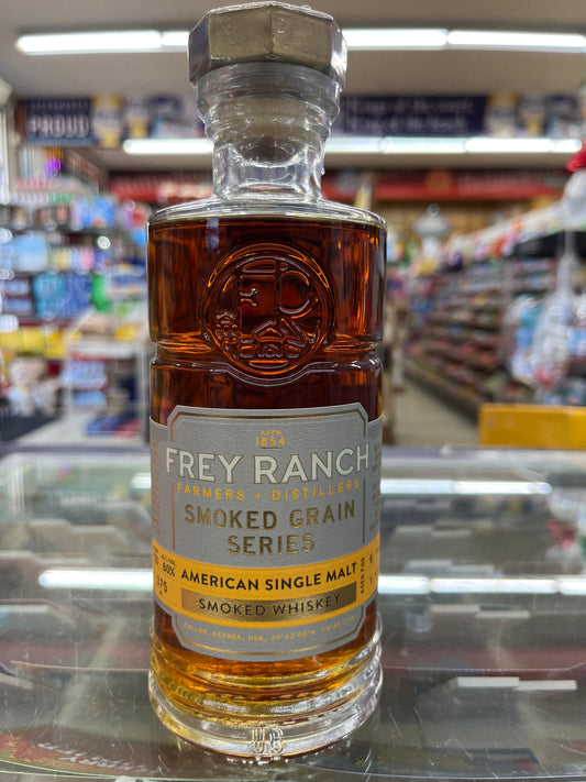 Bottle of Frey Ranch Smoked Grain Series American Single Malt Whiskey Batch 2 on a glass surface with a blurred store background.
