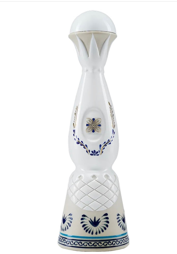 A white ceramic bottle of Clase Azul Anejo tequila with blue floral and geometric patterns, featuring a ribbed textured lower section and a small central blue and gold emblem.