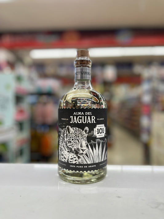 A bottle of Alma Del Jaguar 101 Tequila called  Nocturna on a white counter with a blurred store background.