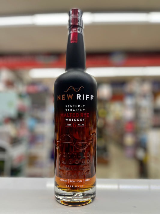 A bottle of New Riff Kentucky Straight Malted Rye Aged 6 years Whiskey standing on a white counter in a blurred retail store environment.