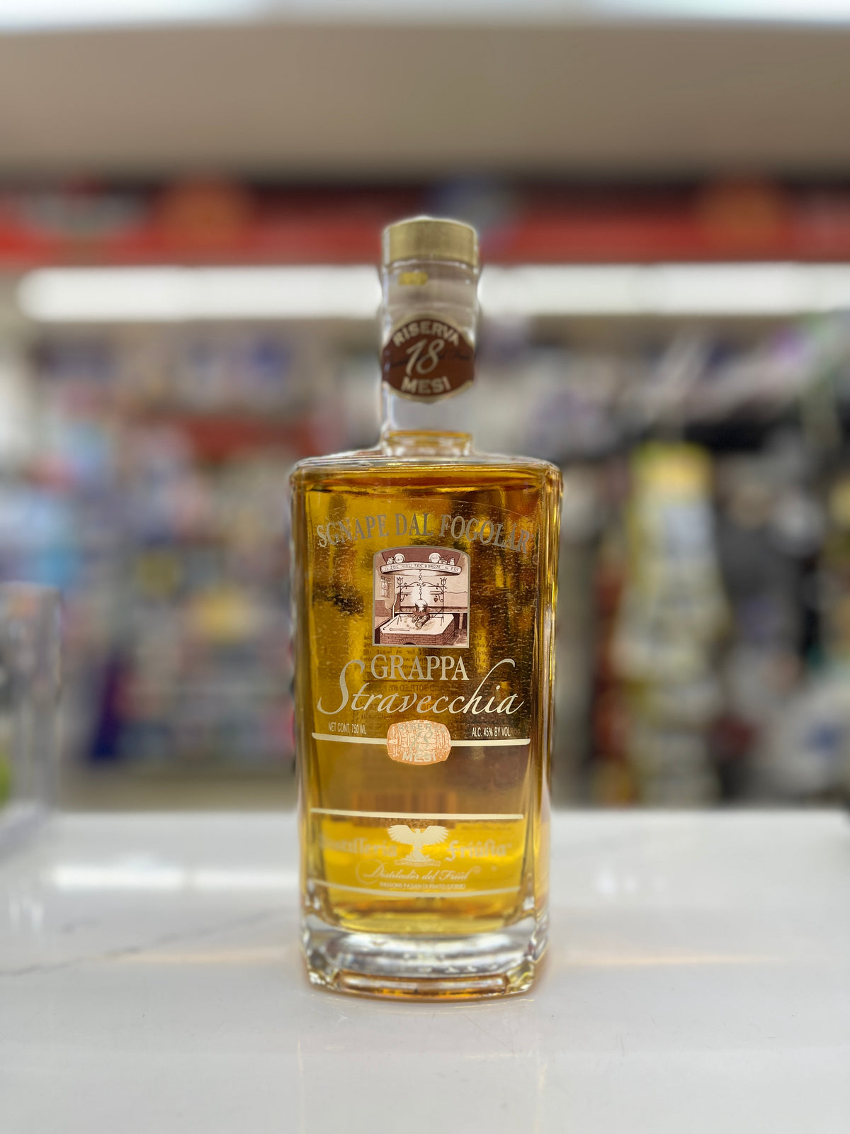 a bottle of Stacecchia Grappa Riserva 18 mesi on a white shelf