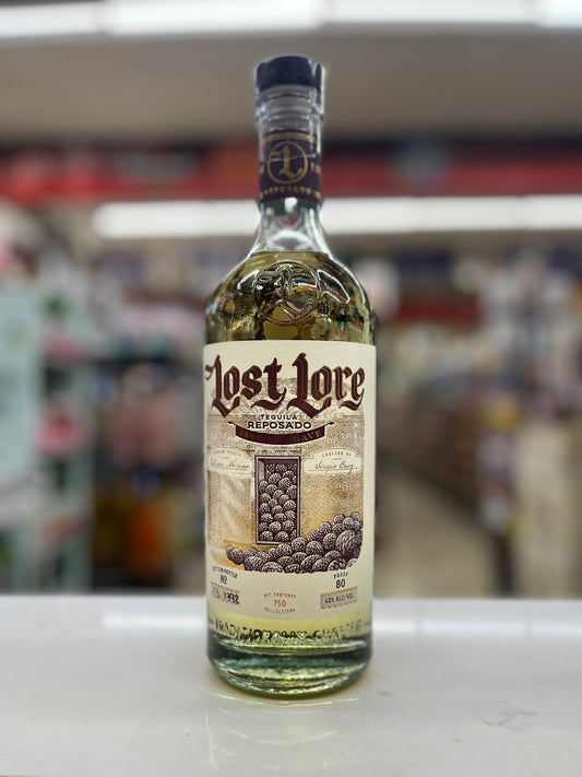 A bottle of Lost Lore Reposado tequila standing on a white counter with a blurred store background.